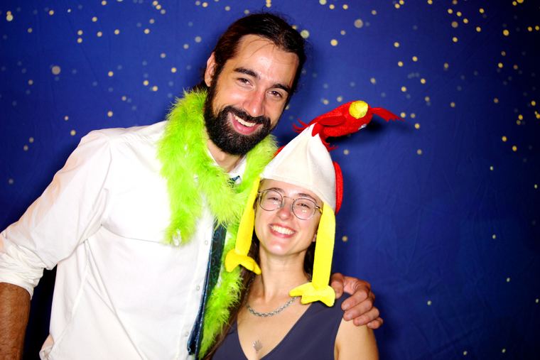 Tall husband leaning naturally toward his shorter wife in a photo booth