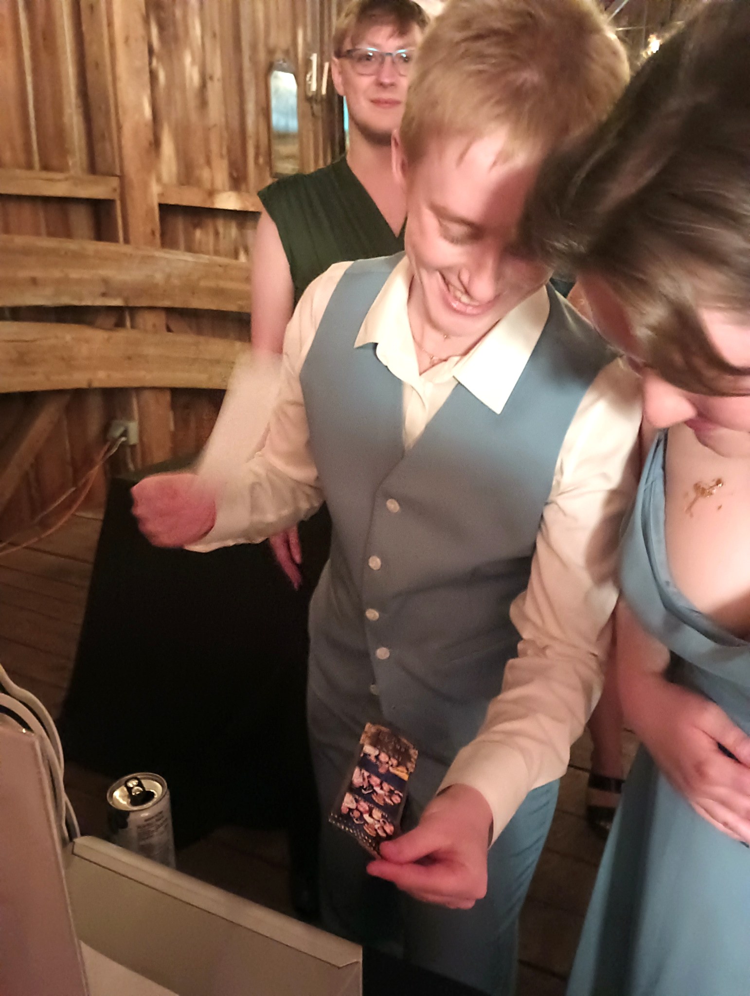 Wedding guests laughing while demonstrating shaking a fresh Lotsa Laffs photo booth print