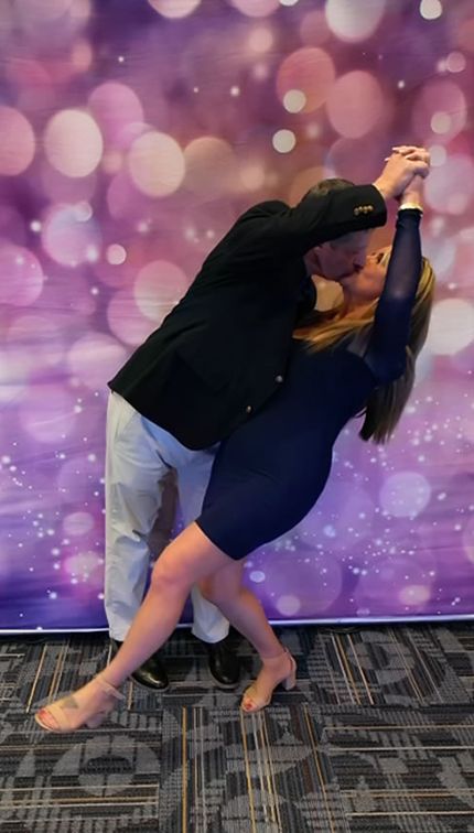 Two event guests creating a dramatic dip and kiss pose together